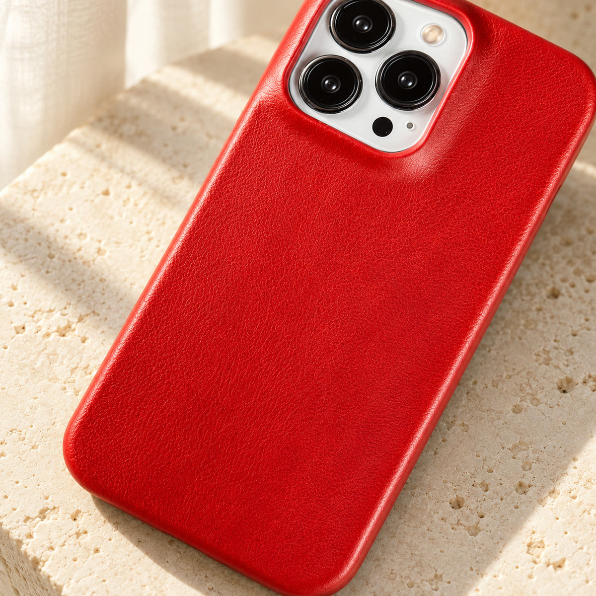 Minimal leather-look iPhone case in Red, close-up of the fine-grained back and rounded corners.