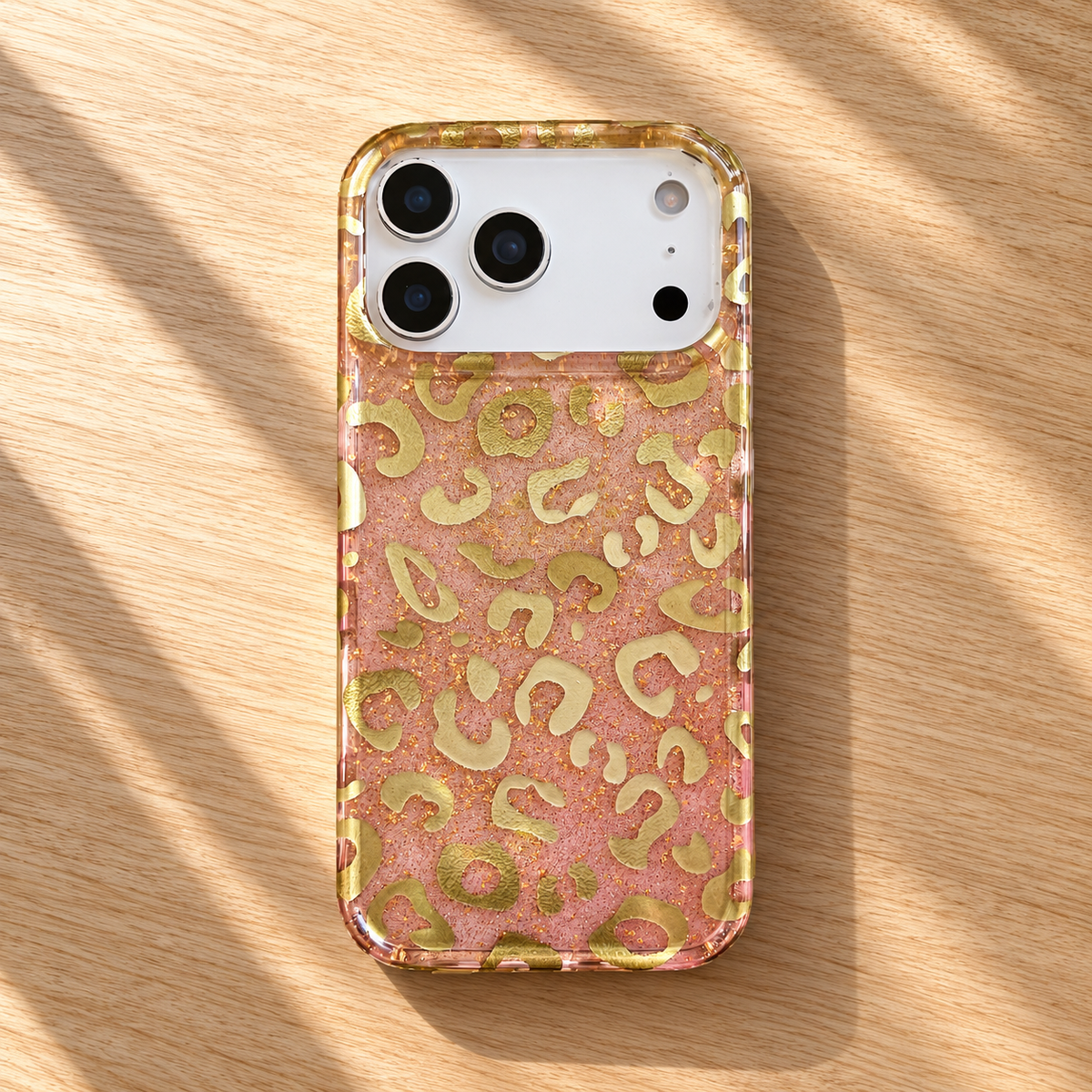 Golden Blush Leopard case styled on a light oak tabletop.