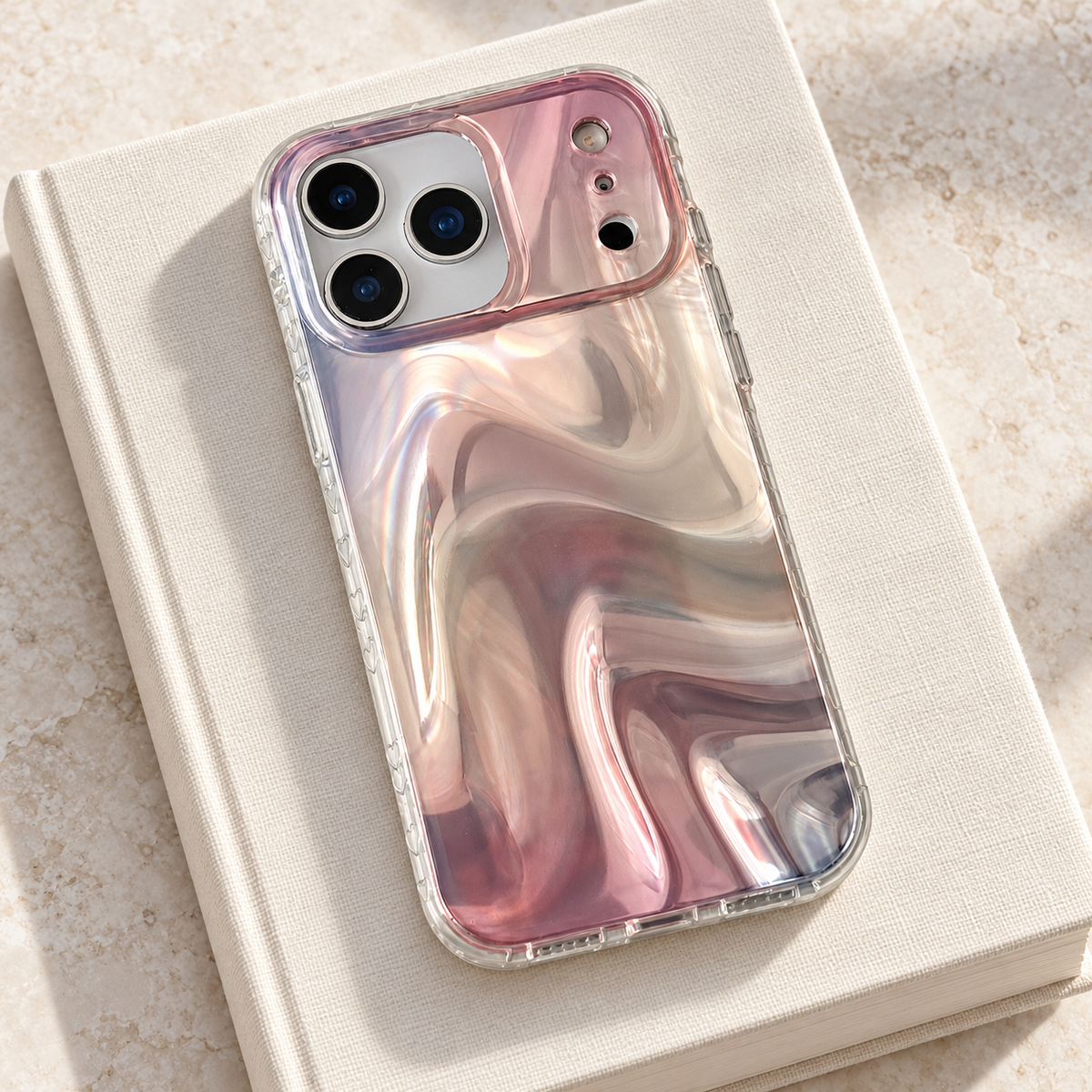 Iridescent Rose case resting diagonally on a plain ivory book.
