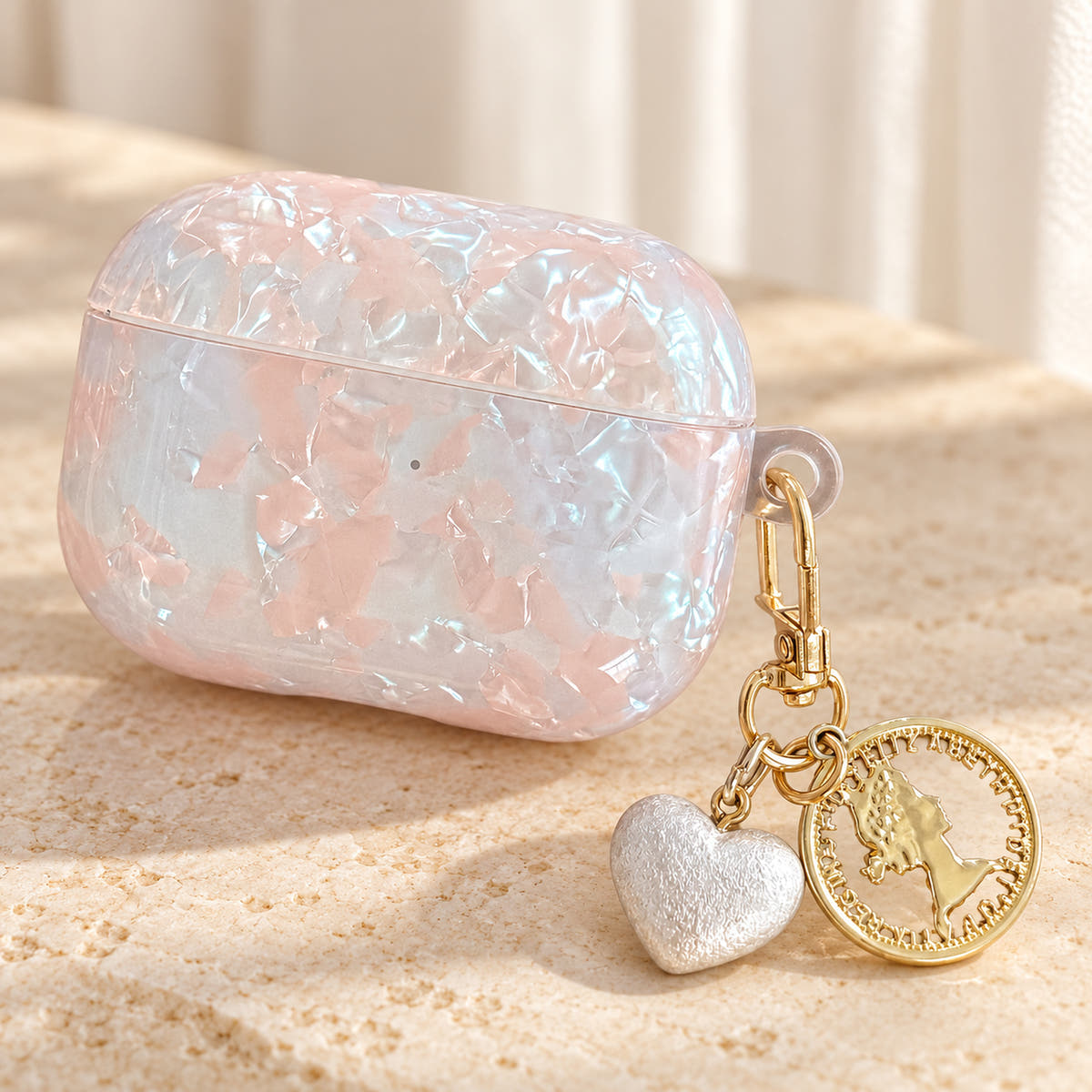 Opal Marble AirPods Case in Opal, clip detail with original attached charms on a warm cream background