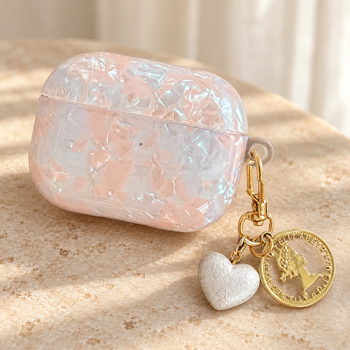 Opal Marble AirPods Case in Opal, finish close with original attached charms on a warm cream background