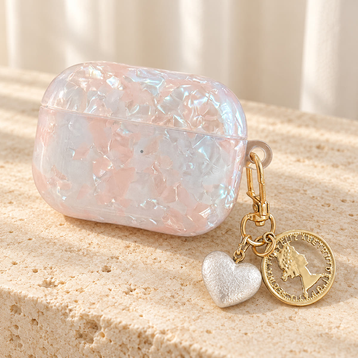 Opal Marble AirPods Case in Opal, front with original attached charms on a warm cream background
