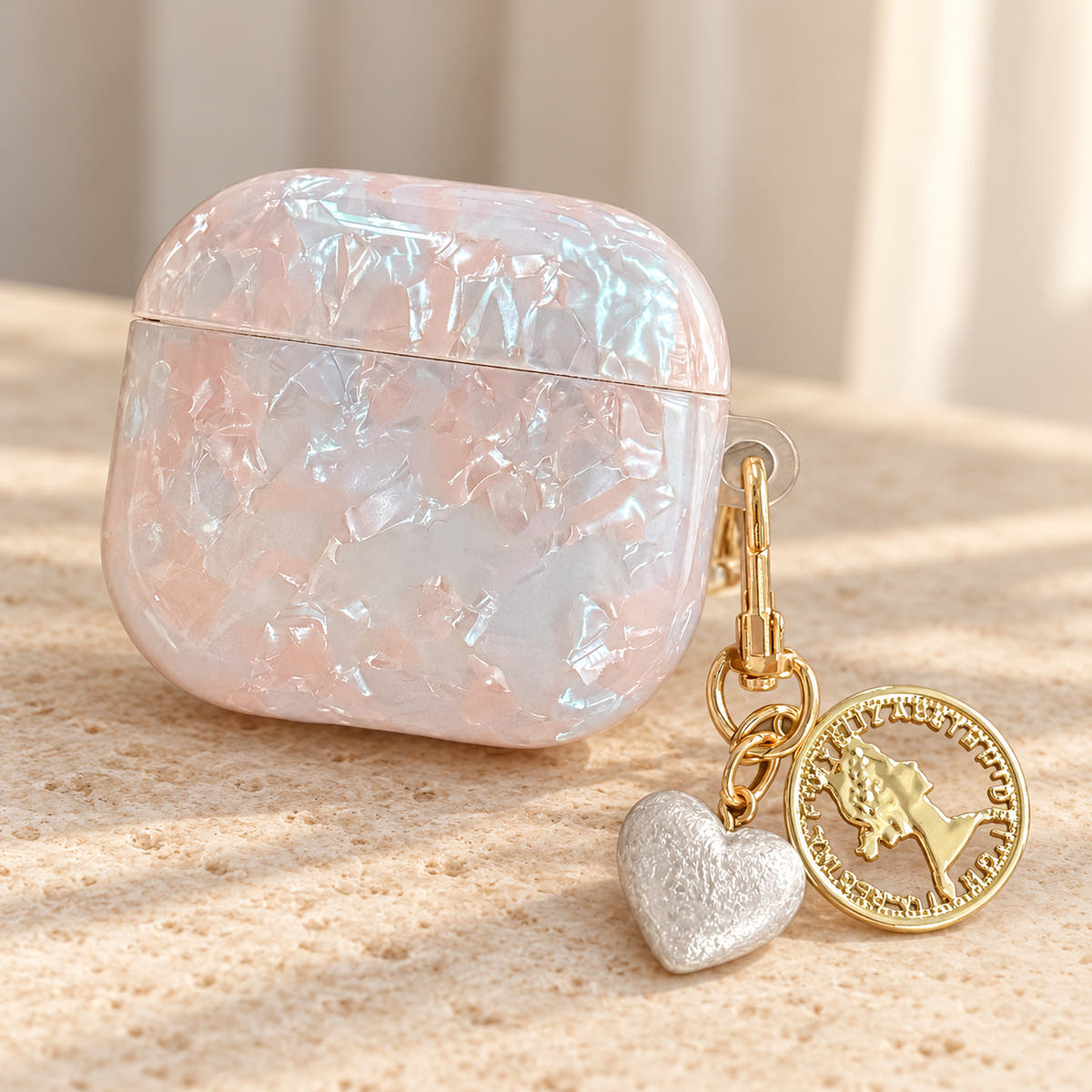 Opal Marble AirPods Case in Opal, lid detail with original attached charms on a warm cream background