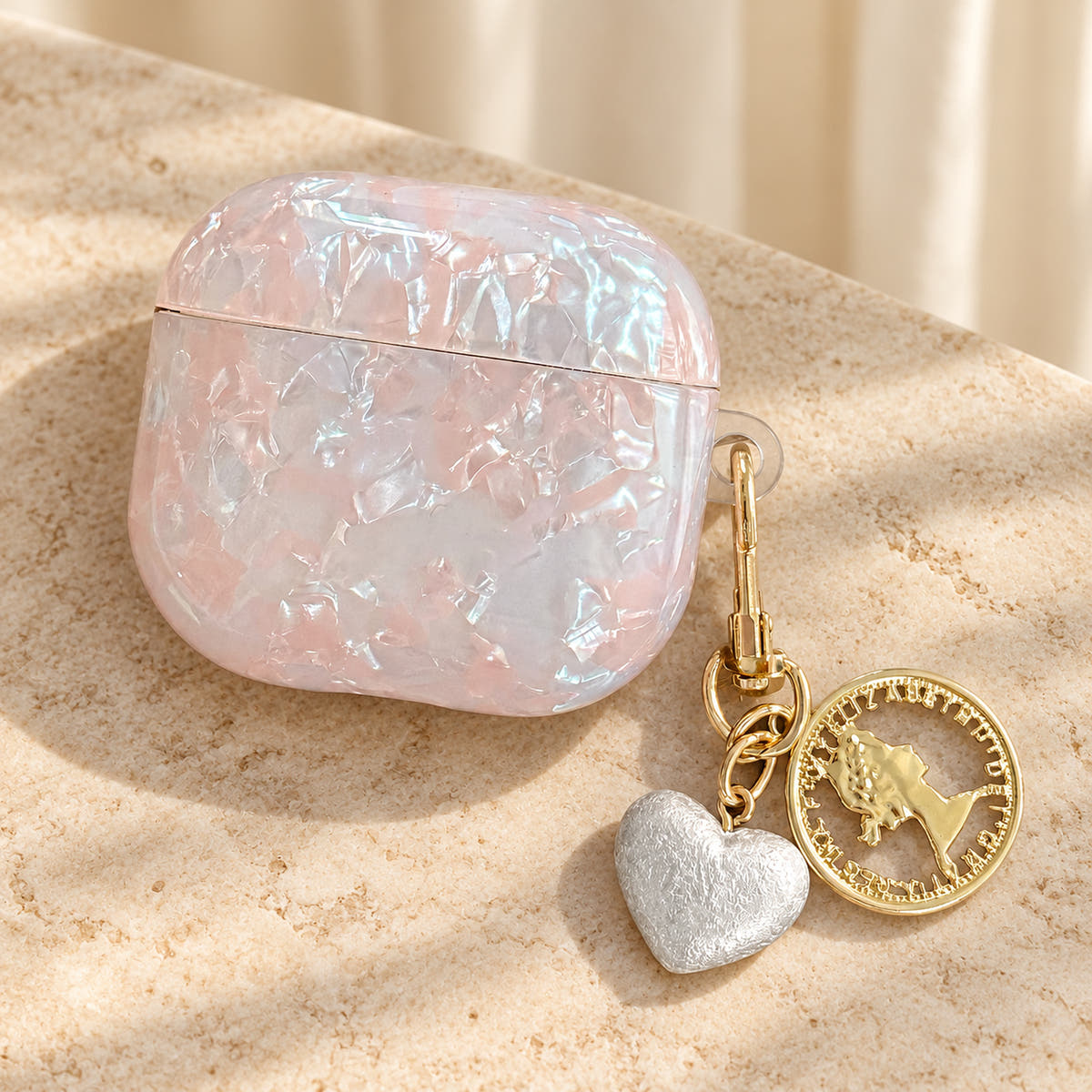 Opal Marble AirPods Case in Opal, overhead tight with original attached charms on a warm cream background