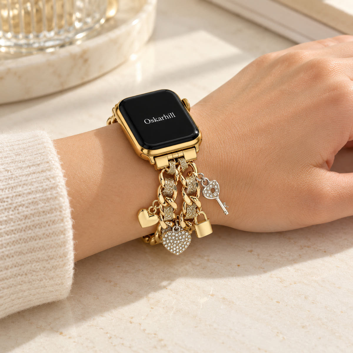 Oskar Hill Amorette Apple Watch charm band — styled on a feminine wrist with an oatmeal knit sleeve