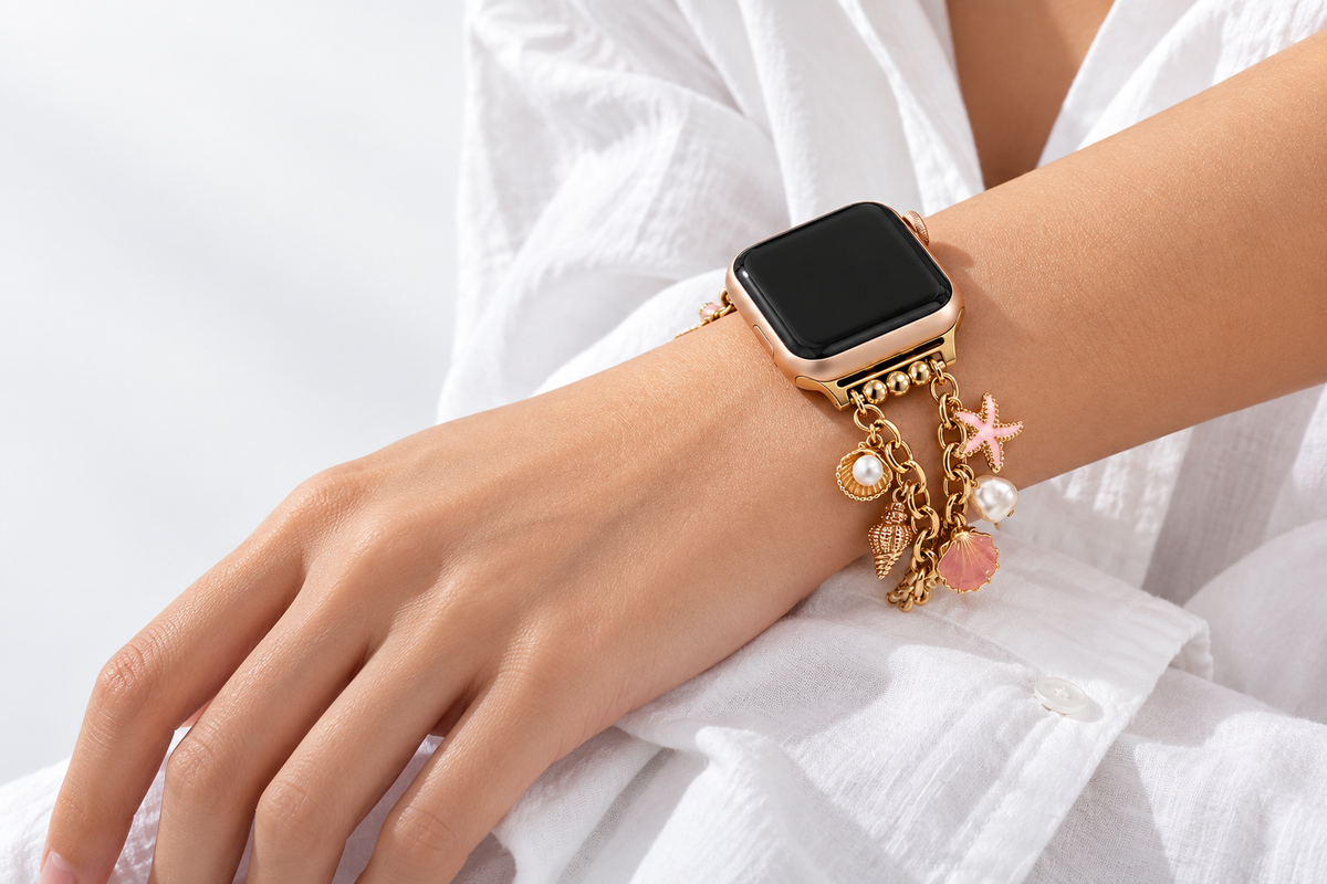 Mariselle gold-tone ocean charm Apple Watch band worn on wrist with crisp white cotton
