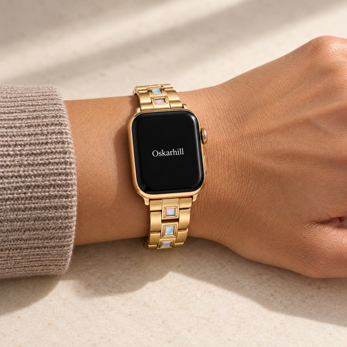 Oskar Hill Seraphine Gold Iridescent Link Apple Watch Band — close wrist view with a taupe knit sleeve