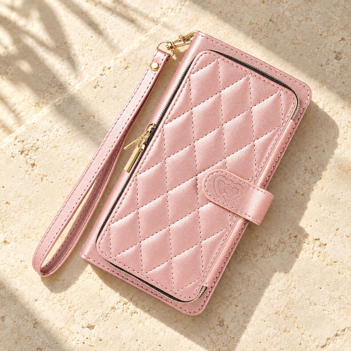 Pink padded zip wallet in an angled flat lay showing quilted front and closure
