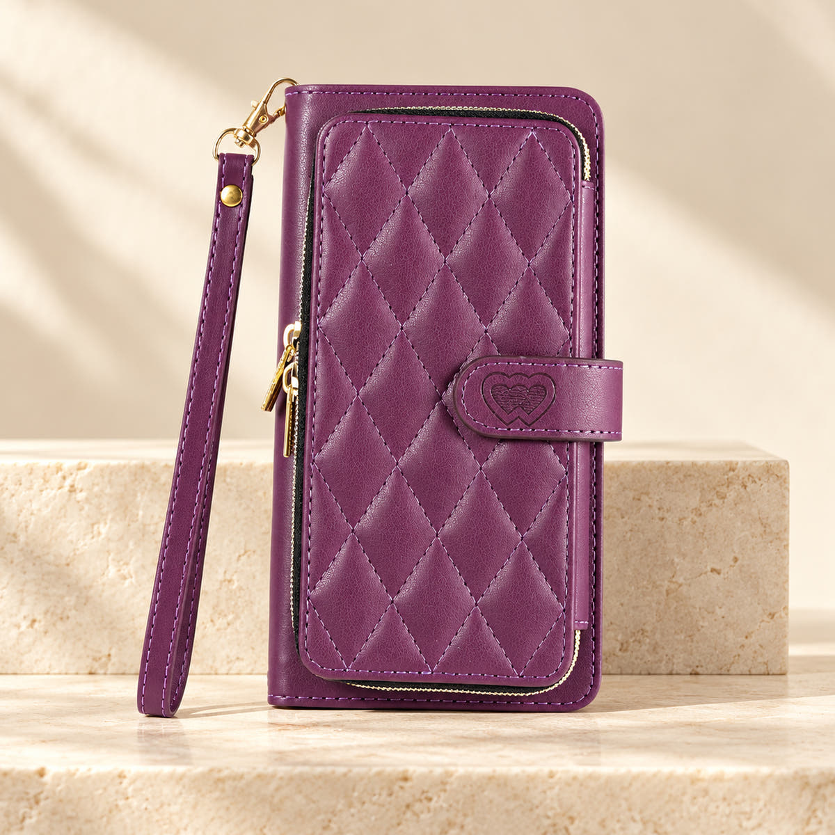 Purple padded zip iPhone wallet case with matching wrist strap on limestone