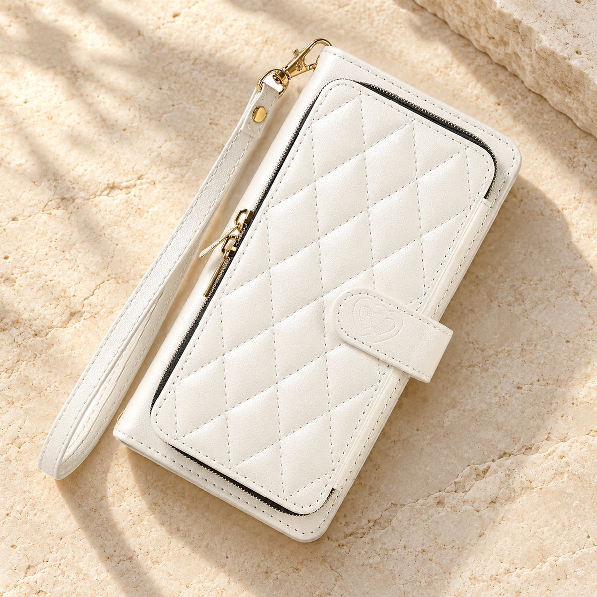 White padded zip wallet in an angled flat lay showing quilted front and closure