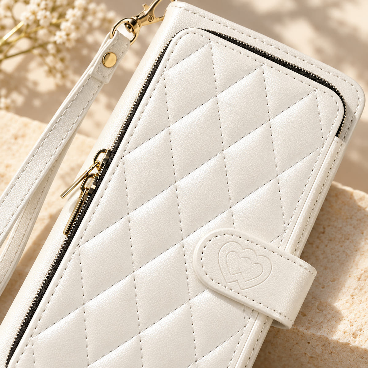 White padded zip wallet close-up of quilting zipper and embossed heart closure