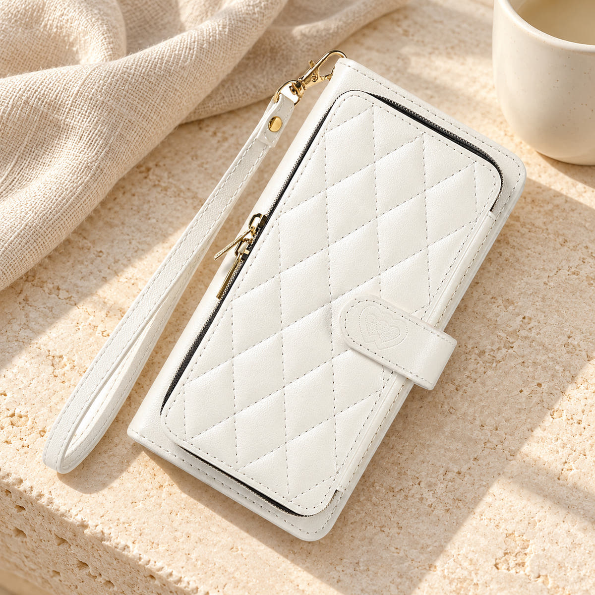 White padded zip wallet with wrist strap in a neutral tabletop setting