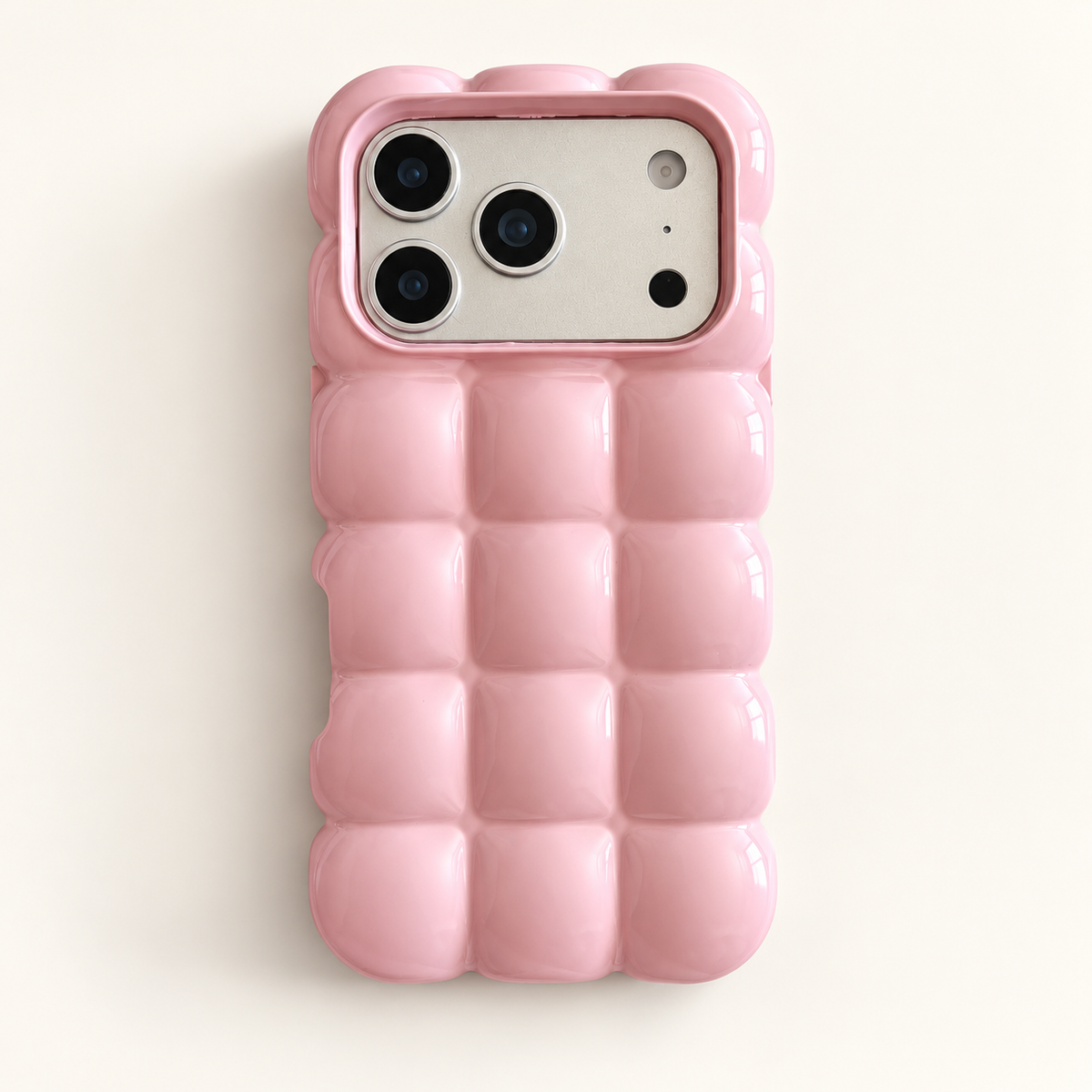 Pink puffy grid iPhone case with rounded-square back and scalloped edges — full rear studio view.