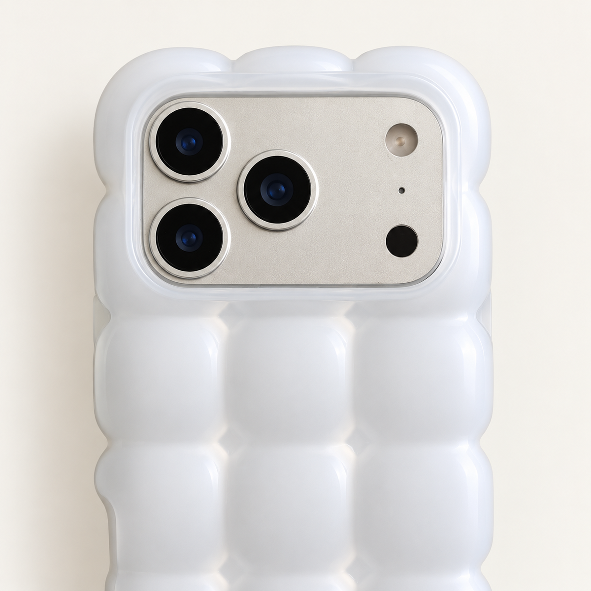 White puffy grid iPhone case with rounded-square back and scalloped edges — close-up of camera surround and sculpted grid.
