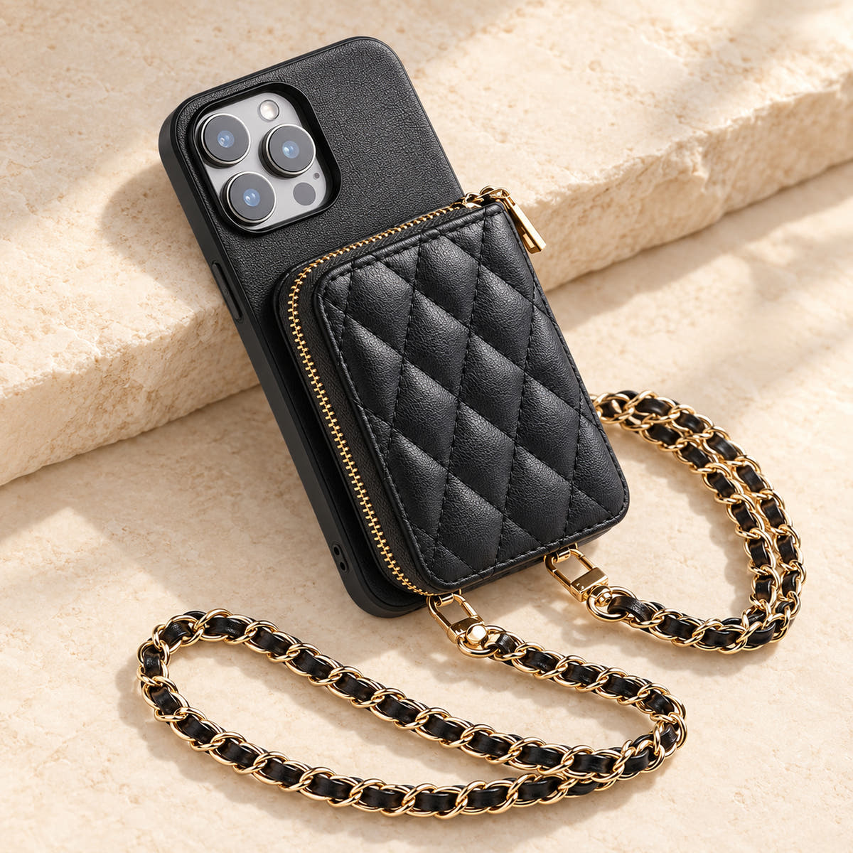 Black quilted iPhone wallet case — quilted wallet and woven chain on a tabletop