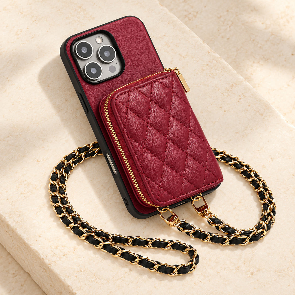 Red quilted iPhone wallet case — quilted wallet and woven chain on a tabletop