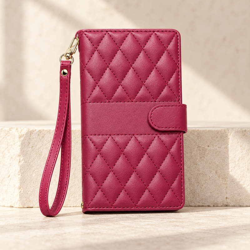 Red quilted iPhone wallet case with matching wrist strap on limestone