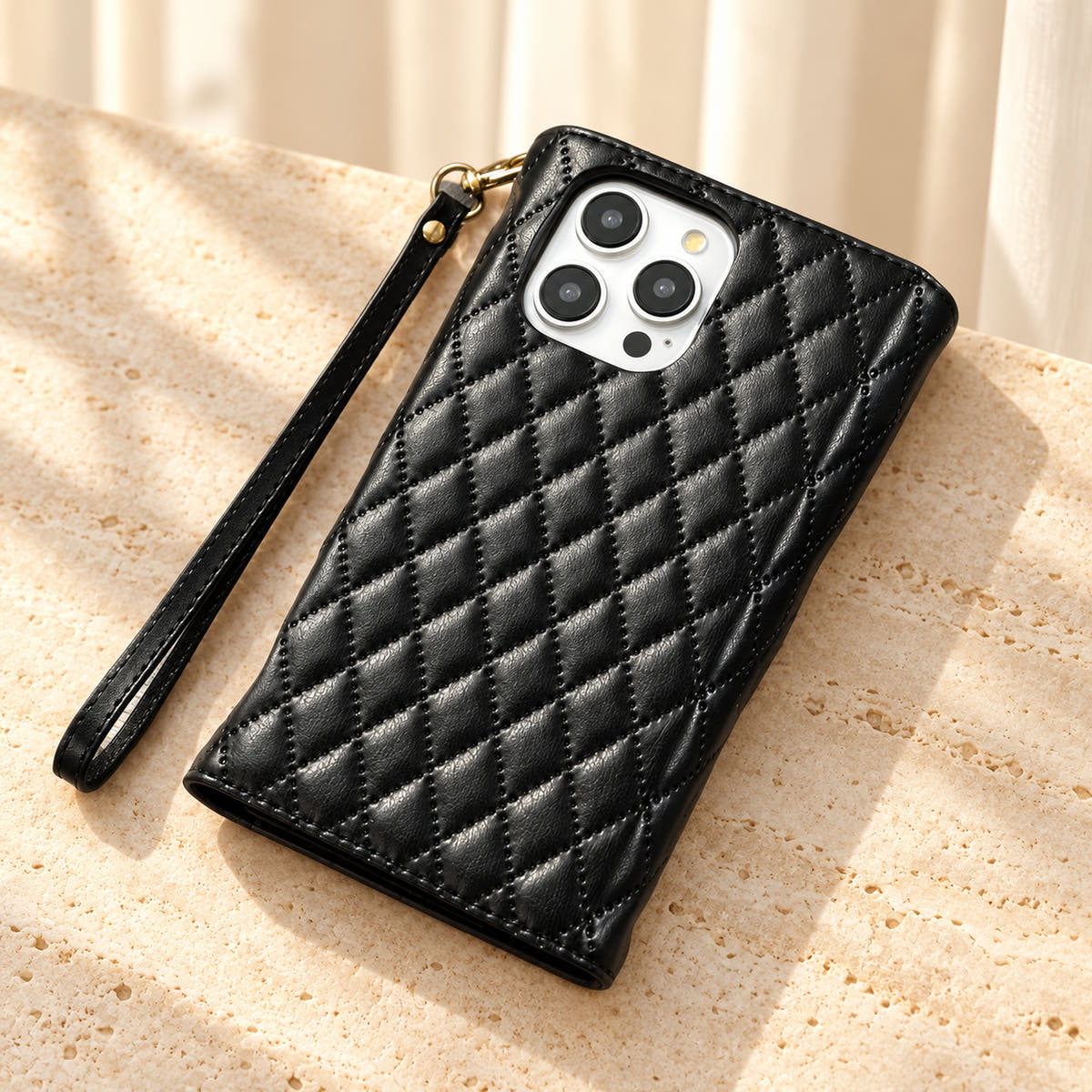 Rear view of the Black Quilted Zip Wallet iPhone case, showing the diamond-quilted back, camera opening and detachable wrist loop.