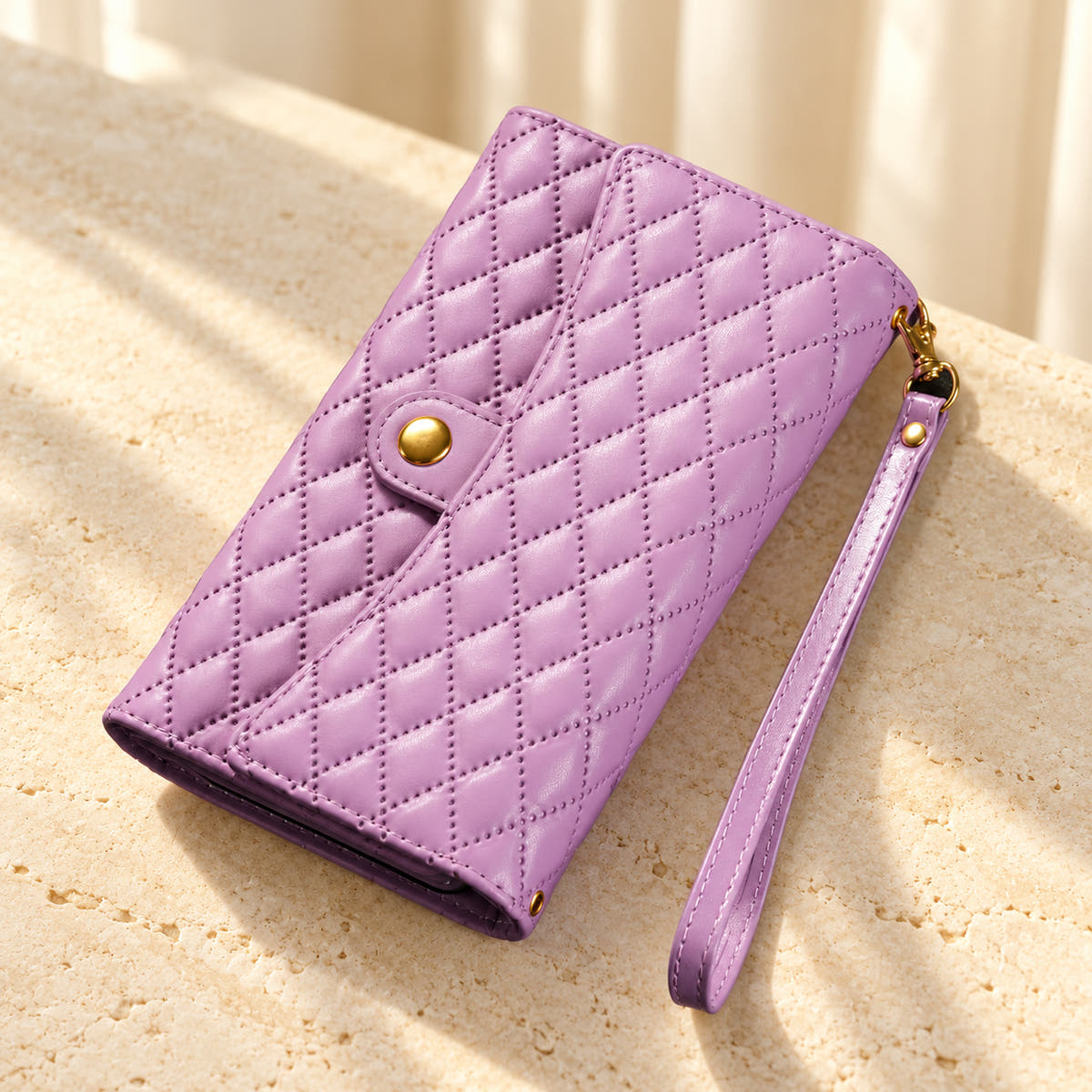 Quilted Zip Wallet iPhone case in Lavender on cream limestone, with the closed diamond-quilted front, snap flap and matching wrist loop.