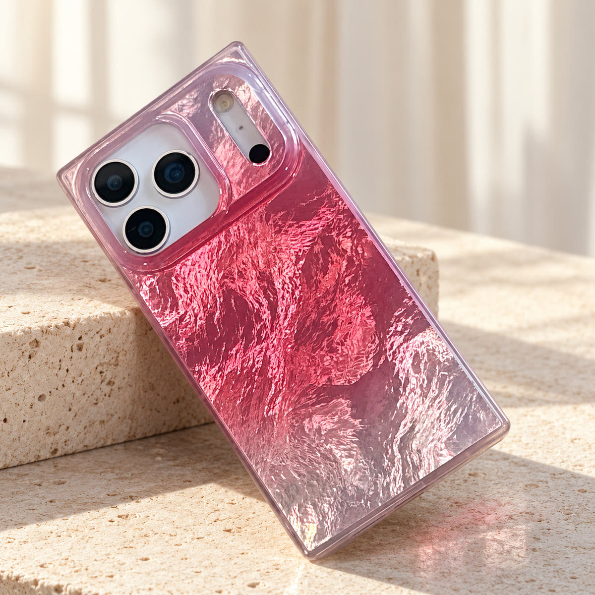 Radiant Wave reflective pink iPhone case in a cream limestone studio composition