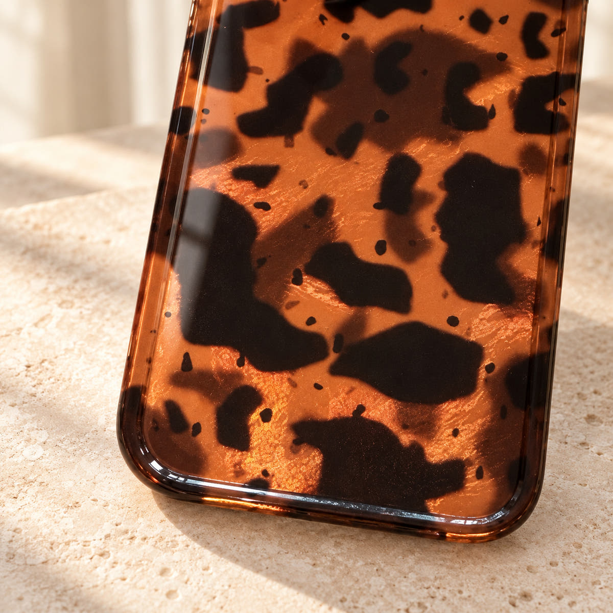 Sienna Luxe Brown gloss-finish detail showing dark tortoiseshell patches, amber tones and a soft natural reflection.