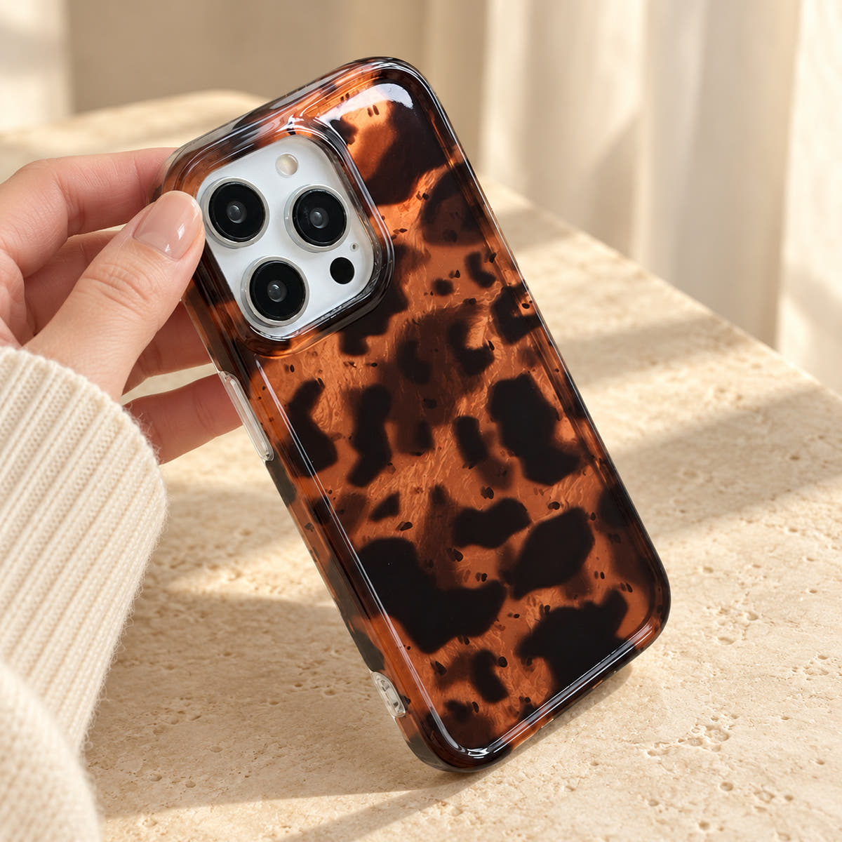 Three-quarter handheld view of Sienna Luxe Brown showing the tortoiseshell back, camera opening and clear side edge.