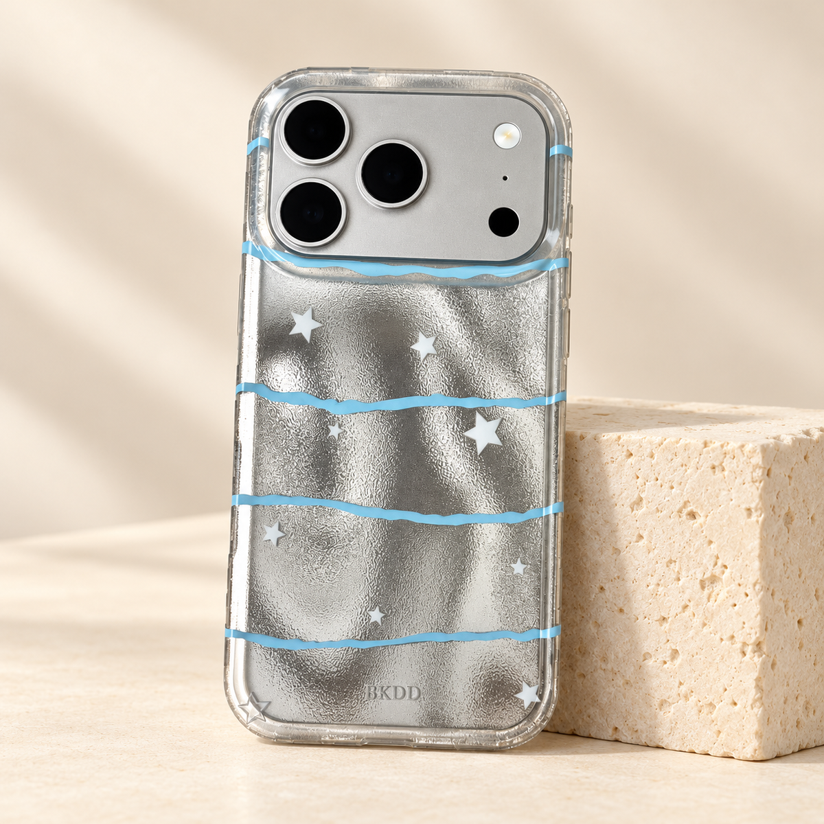 Silver Star Wave case standing against a cream stone block with its complete reflective silver design visible.
