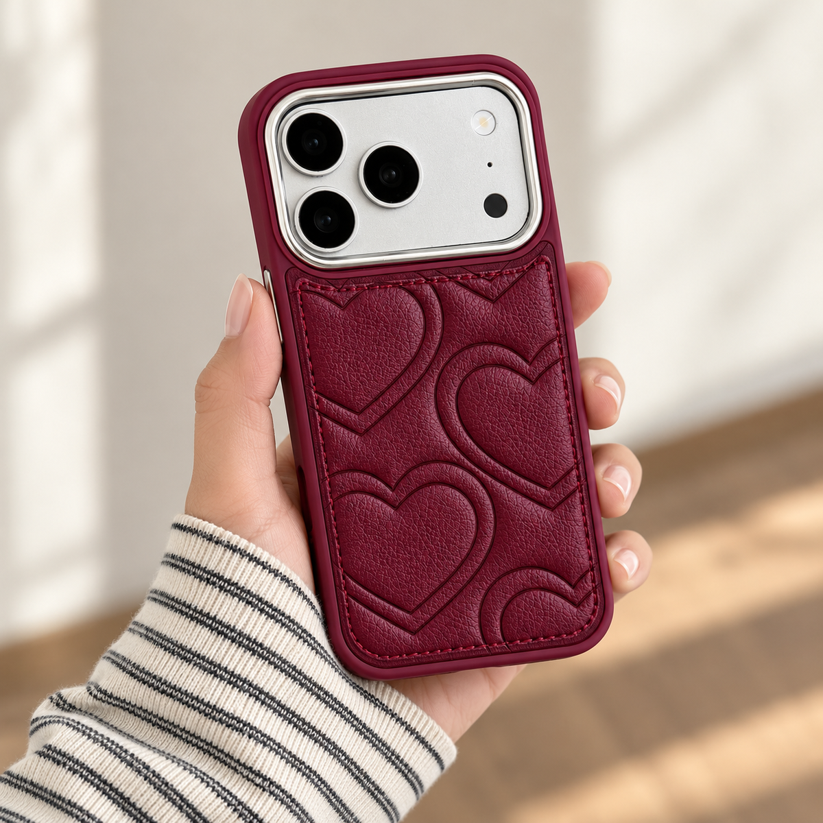 Textured heart iPhone case in Burgundy — handheld rear view.