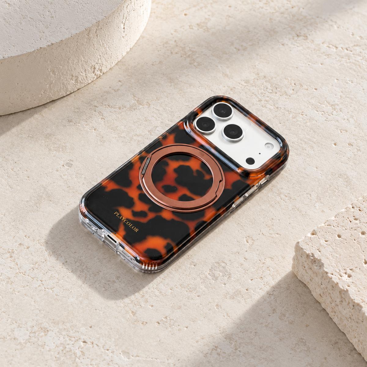 Diagonal flat-lay view of the Amber tortoiseshell iPhone case with ring folded flat.