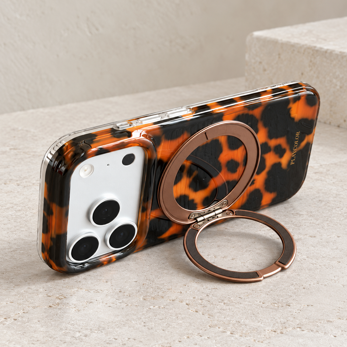 Amber tortoiseshell iPhone case supported horizontally by its fold-out rear ring.