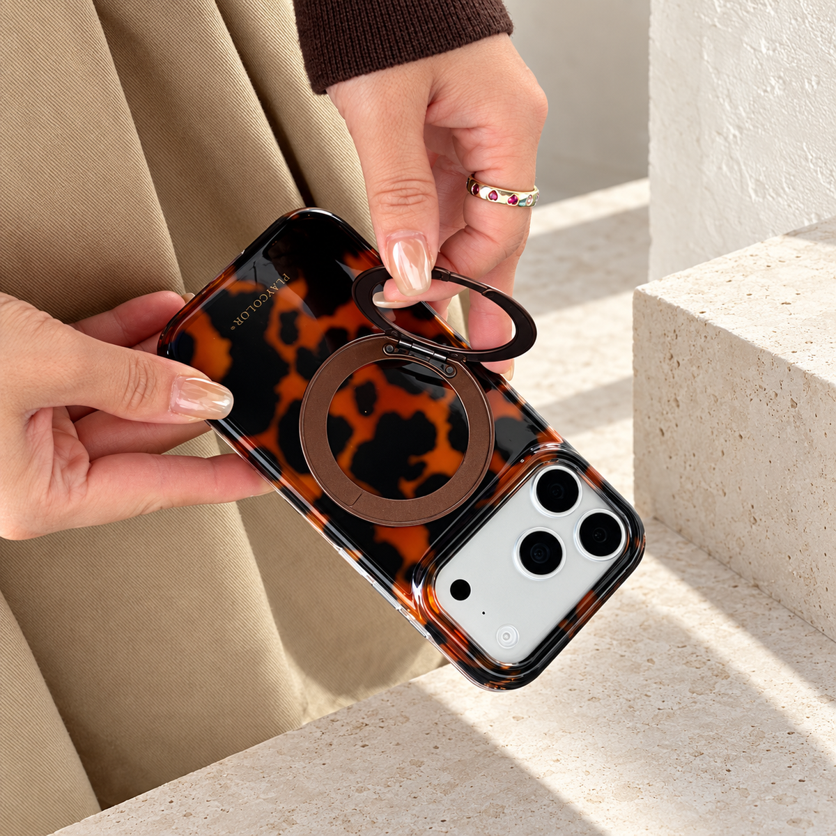 Amber tortoiseshell case with its outer rear ring lifted to show the hinged construction.
