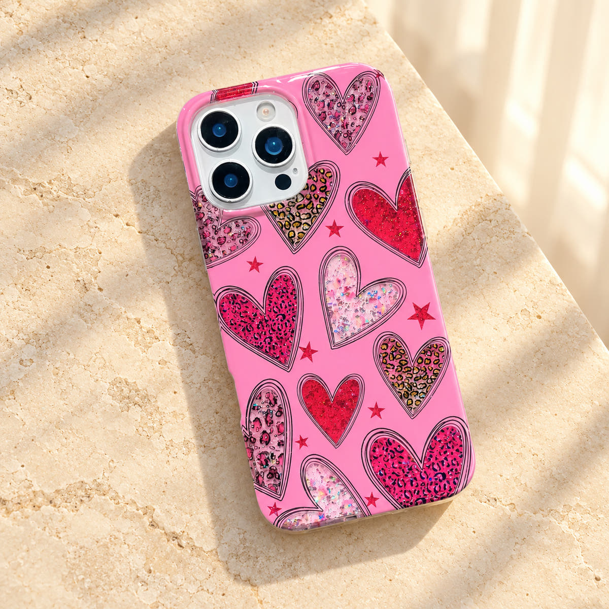 Valentina Sparkle Heart Pink phone case in a tilted flatlay, showing its glossy rear artwork and clear rim.