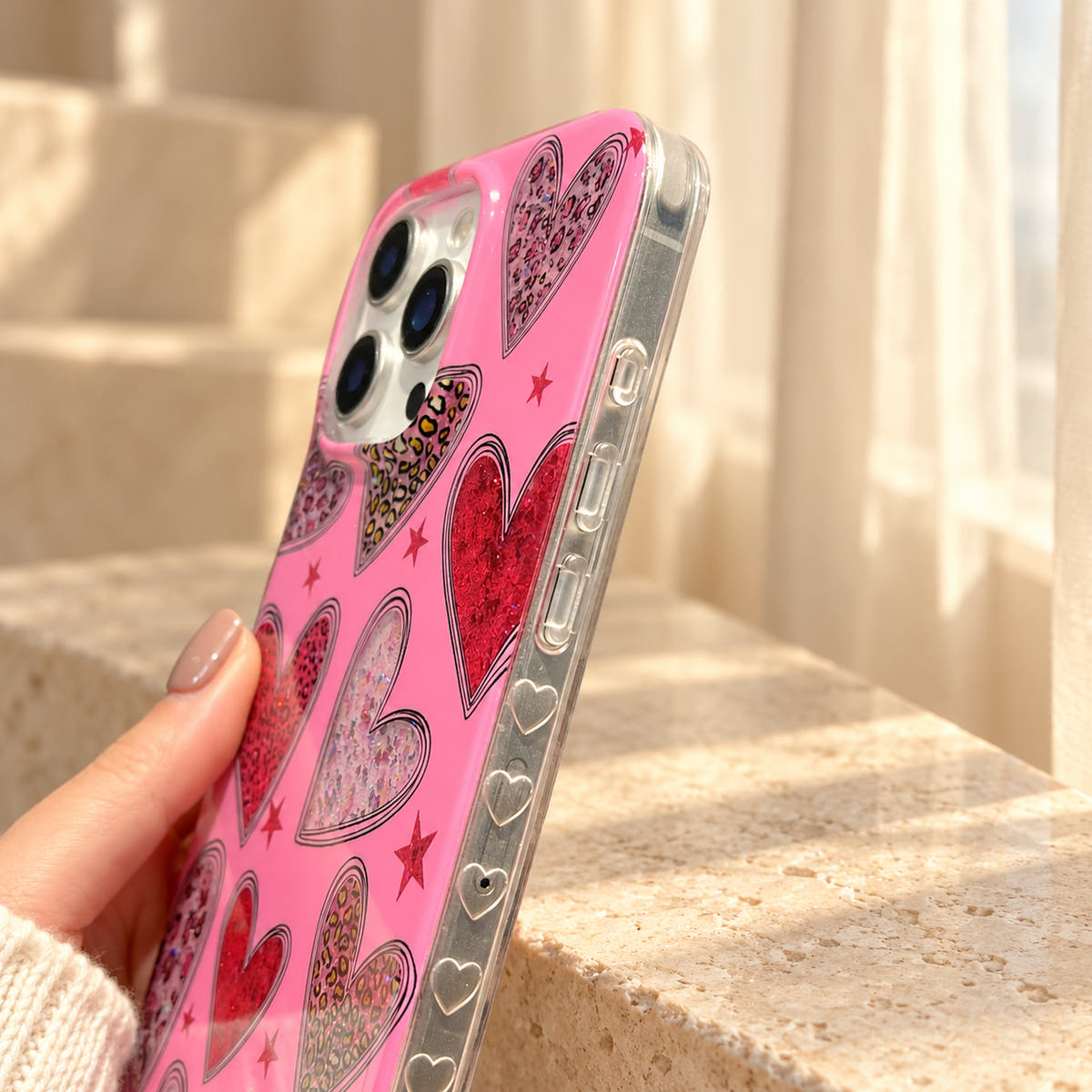 Valentina Sparkle Heart Pink iPhone case side detail, showing clear button covers and moulded heart accents along the rim.