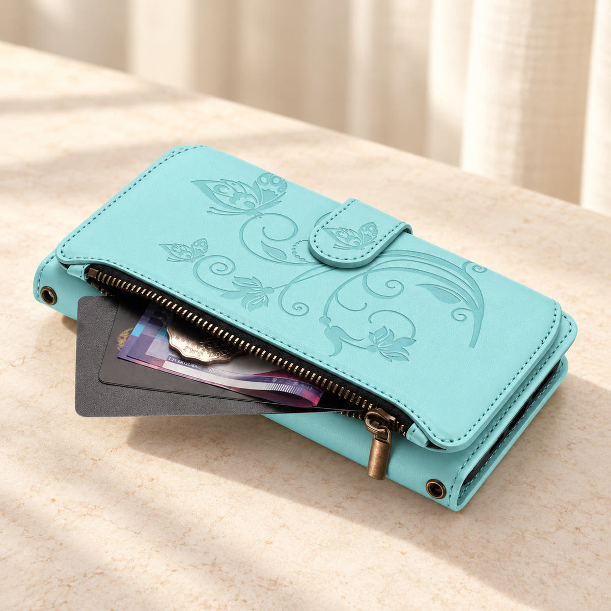 Velora Zip wallet case in Ice Blue on cream limestone, showing the embossed front and open side zip pocket with cards and cash.