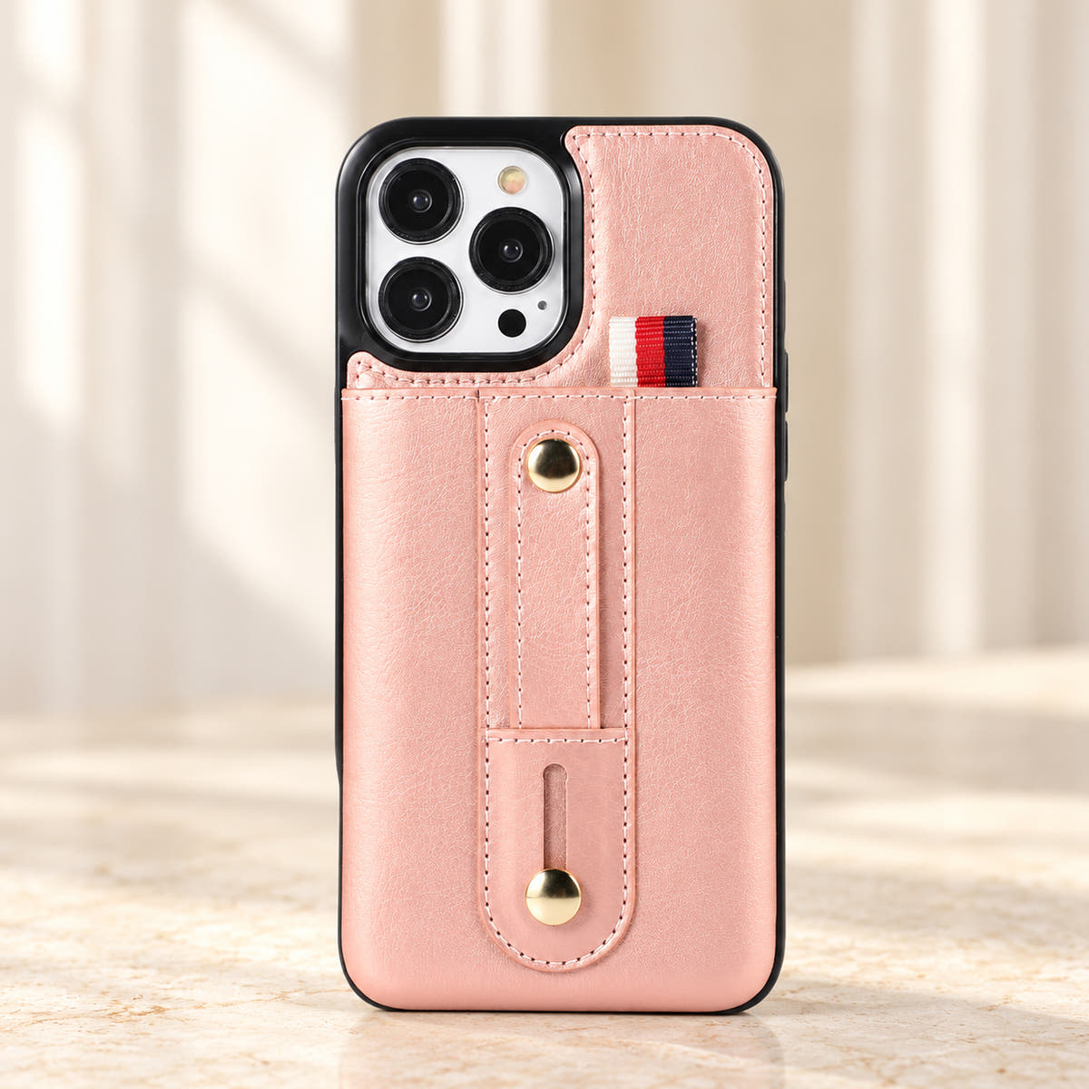 Pink iPhone wallet case with card pocket and adjustable hand strap, front